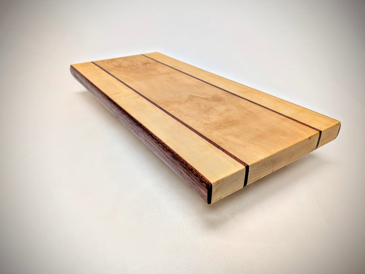 Artisan beech and bloodwood cutting board, featuring a unique design and vibrant, natural color contrast.