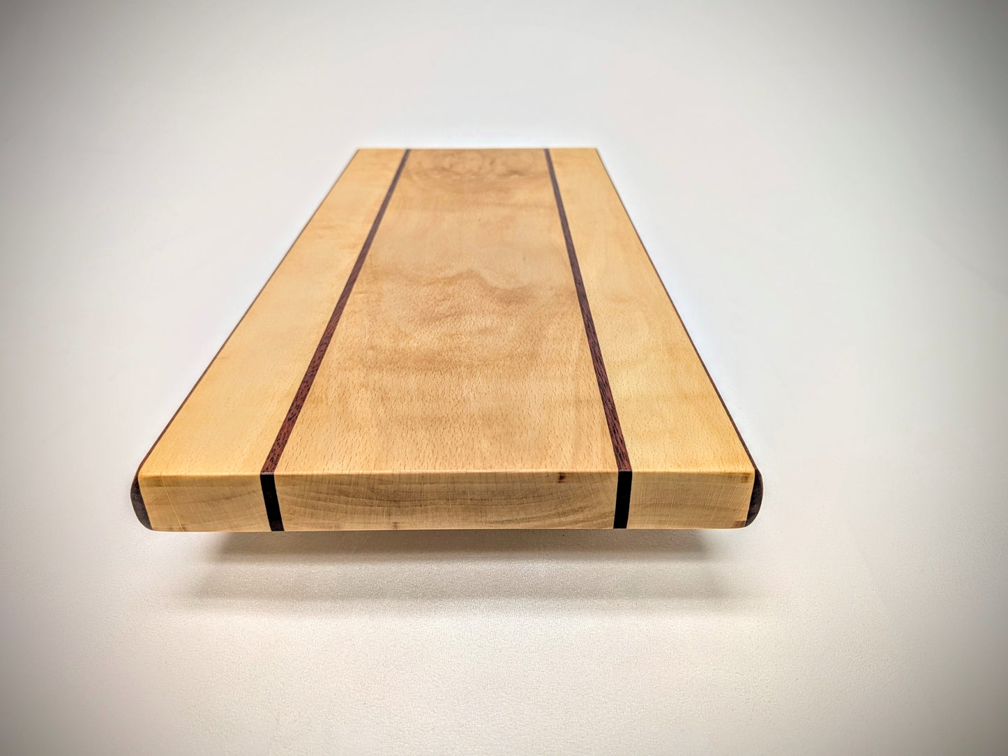 Artisan beech and bloodwood cutting board, featuring a unique design and vibrant, natural color contrast.