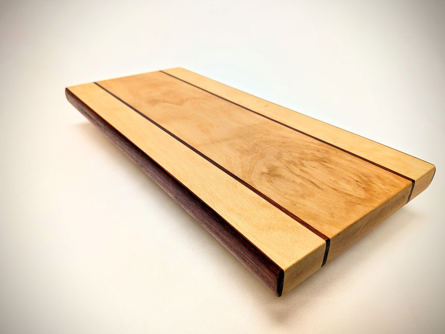 Artisan beech and bloodwood cutting board, featuring a unique design and vibrant, natural color contrast.